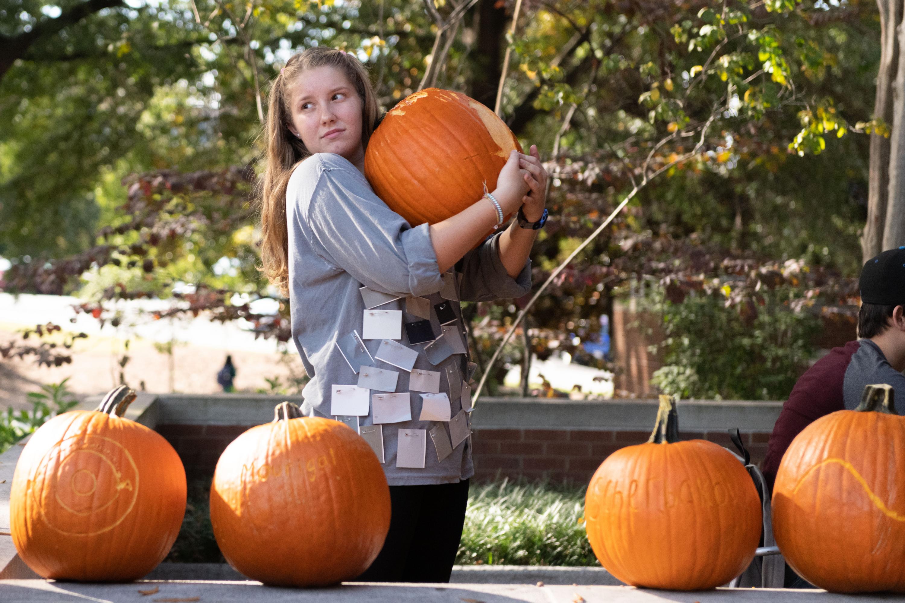 A student holds onto a pumpkin in preparation for the annual School of Physics Pumpkin Drop.