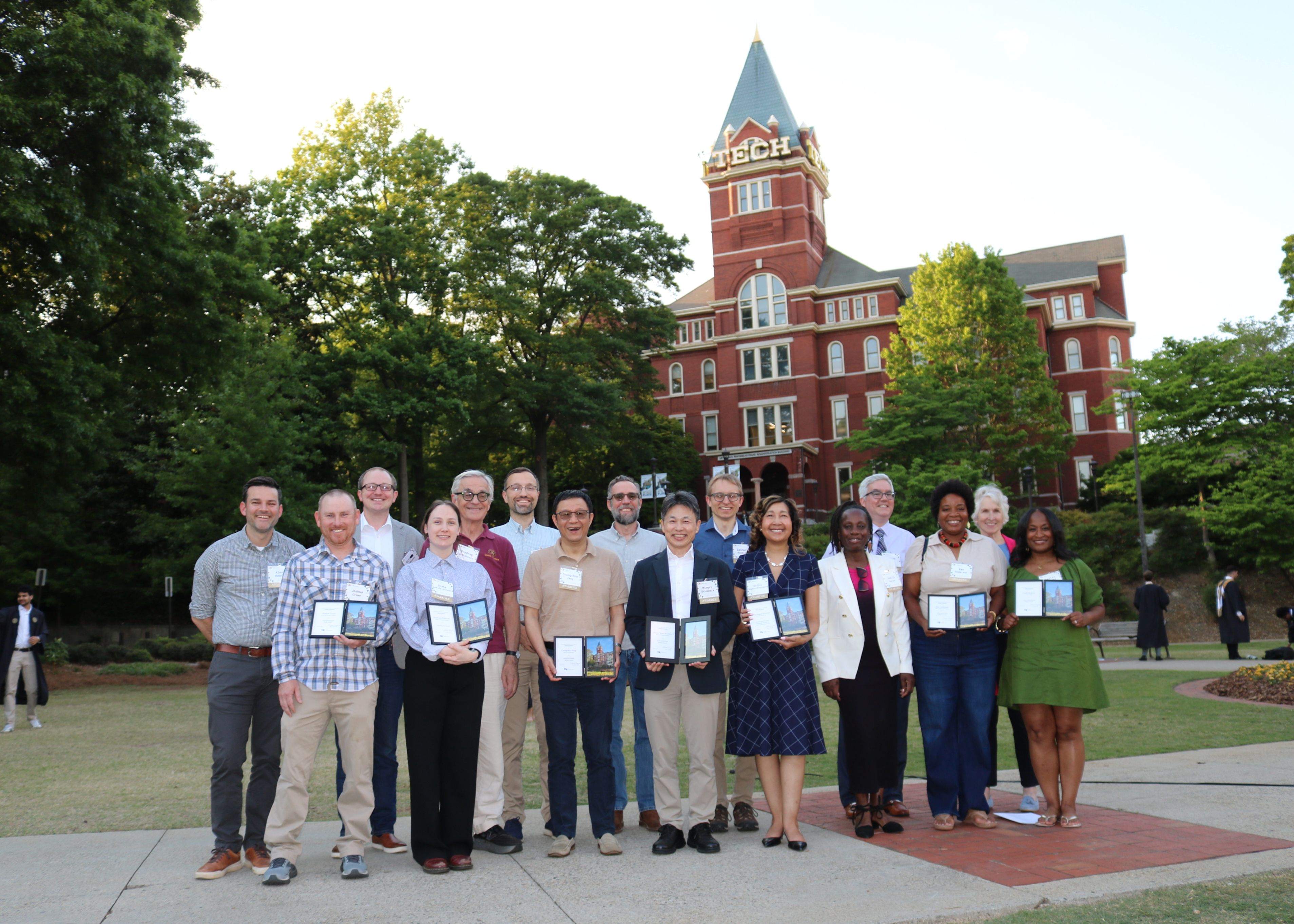 Faculty and staff honorees hold their awards during a group photo in front of Tech Tower 