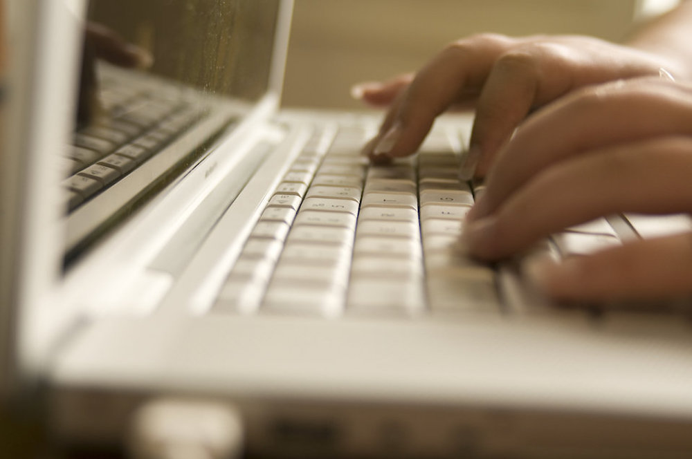 Fingers typing on a laptop keyboard