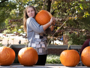 A student holds onto a pumpkin in preparation for the annual School of Physics Pumpkin Drop.
