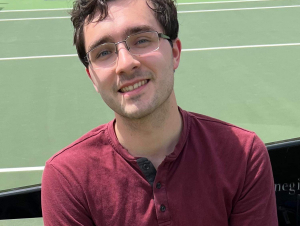 Headshot of a man standing on a tennis court