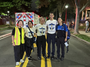 Students stand in front of an ambulance.