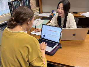 Eunbee Kim provides personalized statistical guidance to a student during a recent Stats HelpDesk session.  A student and woman confer at a desk.