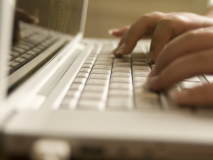 Online learning stock Fingers typing on a laptop keyboard