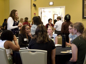 A group of people have a discussion at a round table.